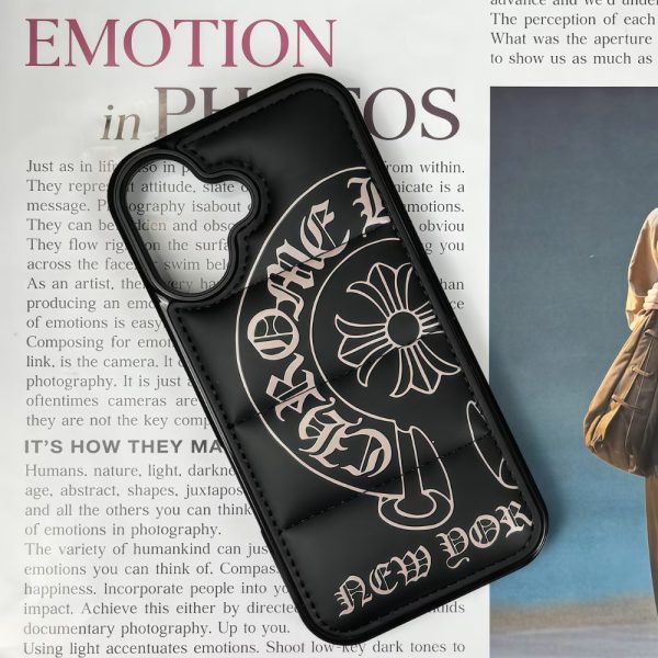 A black puffer Phone case for iPhone 16 or 17 model with Gothic Cross print on a magazine background
